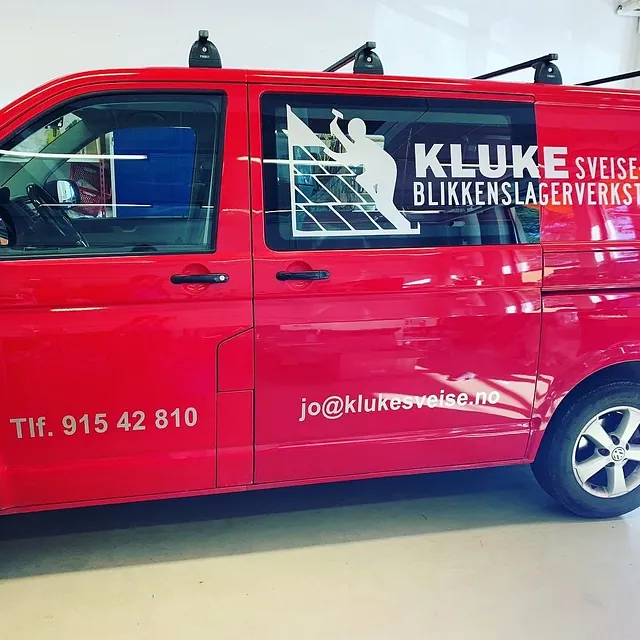 Rød varebil med profilering for Kluke Sveise- og Blikkenslagerverksted AS innendørs.