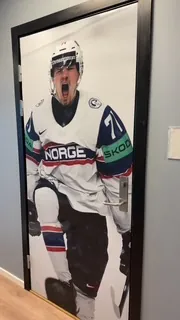 Dør foliert med fotomotiv av ishockeyspiller i landslagsdrakt, montert innendørs.
