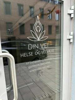 Glassdør med hvit folie for Din Velfære Helse og Velvære og kontaktinformasjon.