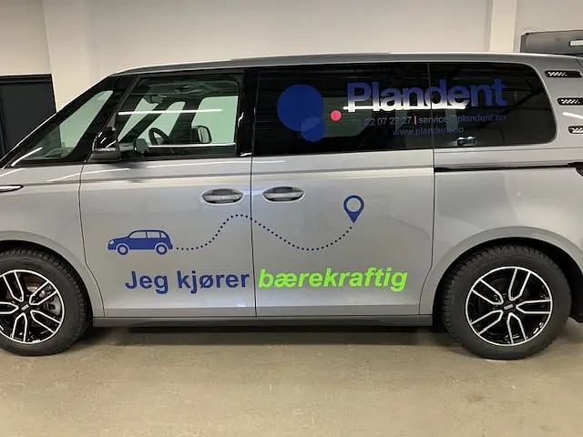 Elektrisk varebil med Plandent-profilering og budskap om bærekraftig kjøring i lokale.