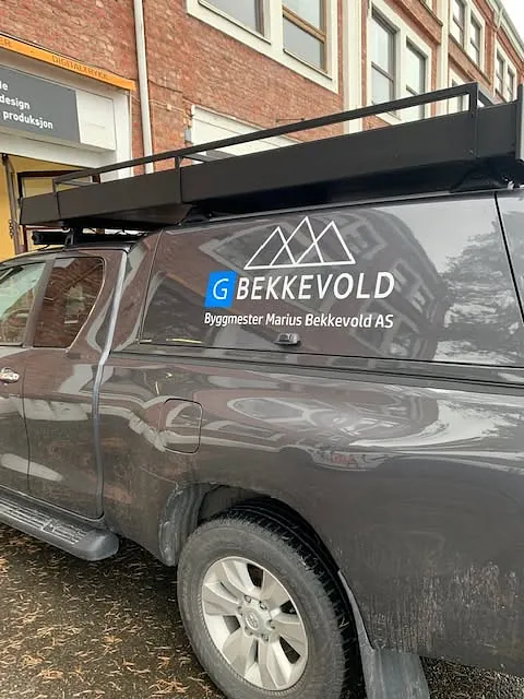 Nærbilde av firmaprofilering for Bekkevold Byggmester AS på mørk pickup.