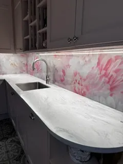 Baderomsinnredning med dekorvegg i rosa blomstermønster bak servant og speil.