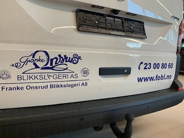 Nærbilde av bakdør på varebil med logo, kontaktinformasjon og folieprofilering.