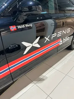 Sort XPENG med profilering, norske fargestriper og logo langs sidedøren.