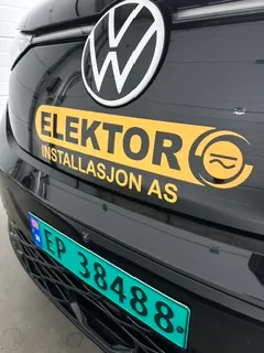 Nærbilde av Volkswagen med profilering for Elektor Installasjon AS på sort panser.
